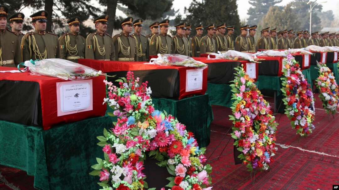 Anggota pasukan kehormatan berdiri tegak di dekat peti jenazah tentara Afghanistan korban serangan Taliban, dalam upacara pemakaman di Kabul, Afghanistan (24/2).
