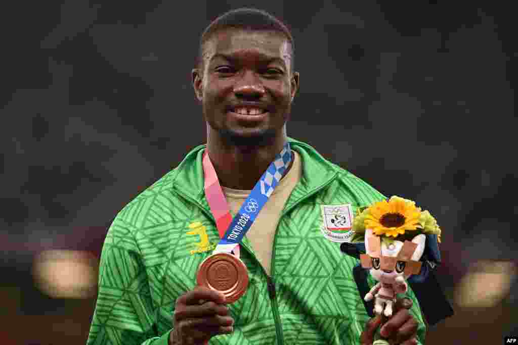Bronze medallist Burkina Faso's Hugues Fabrice Zango poses with his medal on the podium after the men's triple jump event during the Tokyo 2020 Olympic Games at the Olympic Stadium in Tokyo on August 5, 2021. (Photo by Ina FASSBENDER / AFP)