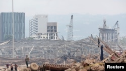 Personas en el lugar devastado de la explosión en el puerto de Beirut, Líbano, 6 de agosto de 2020.