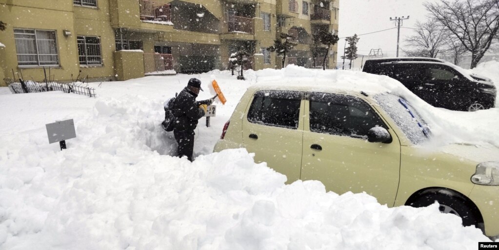 资料照：日本北海道地区北见市的一名男子从深雪中挖出汽车。（2022年12月24日）(photo:VOA)