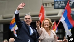 Uruguay's incoming President Yamandu Orsi and Vice President Carolina Cosse wave as they ride in an open car on Inauguration Day, in Montevideo, March 1, 2025. 