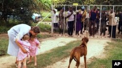 FILE: Pippa van Rechteren, left, and her two-year-old twins are blocked from leaving their house on the white-owned commercial farm, Chiripiro, by Zimbabwe war veterans in Centenary district, north of Harare, March 29, 2000. (AP)