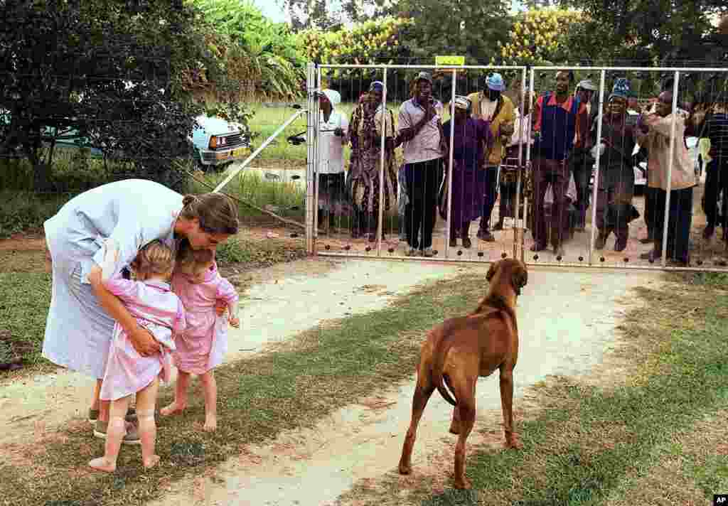 Pippa van Rechteren, left, and her two-year-old twins are blocked from leaving their house on the white-owned commercial farm, Chiripiro, by Zimbabwe war veterans in Centenary district, north of Harare, March 29, 2000. (AP)