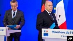 German Interior Minister Thomas de Maiziere, left, and French Interior Minister Bernard Cazeneuve arrive for a joint media conference in Paris, Aug. 23, 2016. 