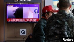 People watch a TV broadcasting a news report on North Korea firing three ballistic missiles into the sea, in Seoul, South Korea, Nov. 2, 2022. 