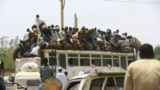 FILE: In an earlier time before the conflict now tearing Sudan apart, people ride on a bus as they return to their families ahead of the Eid al-Adha festival in Khartoum, on Sept. 11, 2016. 