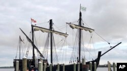 Spectators watch as a replica of one of Christopher Columbus' ships, the Pinta, is moored, Feb. 19, 2020, in Biloxi, Miss. 