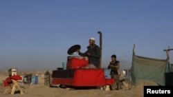 An Afghan man prepares food at his roadside restaurant in Kabul, November 14, 2012.