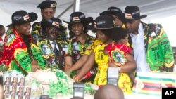 Le président zimbabwéen Robert Mugabe, centre gauche, son épouse Grace, au centre, et des membres de leur famille coupent le gâteau d'anniversaire à Matopos, dans la banlieue de Bulawayo, 25 février 2017. 