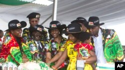 Le président zimbabwéen Robert Mugabe, centre gauche, son épouse Grace, au centre, et des membres de leur famille coupent le gâteau d'anniversaire à Matopos, dans la banlieue de Bulawayo, 25 février 2017. 