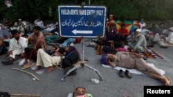 Para pendukung Mohammad Tahir ul-Qadri, ulama sufi dan pemimpin partai Pakistan Awami Tehreek (PAT), tidur-tiduran di gerbang masuk gedung parlemen di Islamabad (20/8).