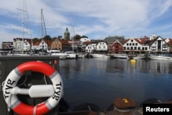 A lifebuoy is seen in front of boats in Stavanger harbor, Norway, Aug. 1, 2018.