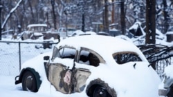 Snow left by a fast-moving winter storm covers the charred remains of vehicles destroyed by wildfires Jan. 6, 2022, in Superior, Colo.