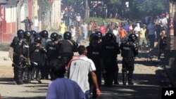 Riot police officers face demonstrators during clashes in La Paz Centro, Leon, Nicaragua, Monday, Nov 5, 2012. The ruling Sandinista Front has won at least 134 of the 153 mayoral races in local elections the opposition and the U.S. government say lacked transparency, according to results released Monday. 
