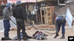 FILE: Armed Zimbabwean police beat up alleged rioters in Harare, Monday, July, 6, 2016. (AP Photo/Tsvangirayi Mukwazhi)