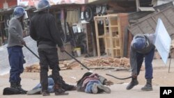 FILE: Armed Zimbabwean police beat alleged rioters in Harare, Monday, July, 4, 2016. (AP Photo/Tsvangirayi Mukwazhi)