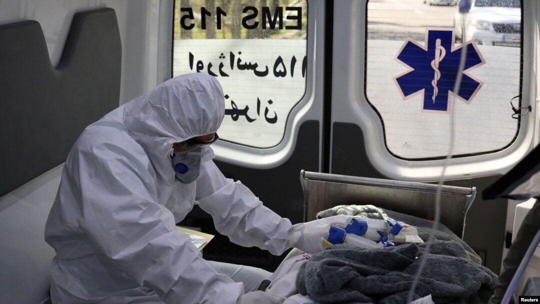 
Seorang anggota staf medis darurat yang mengenakan pakaian pelindung, duduk di ambulans saat memindahkan pasien Covid-19 ke Rumah Sakit Masih Daneshvari, di Teheran, Iran, 30 Maret 2020. (Foto: West Asia News Agency via Reuters)
