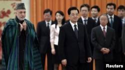 Chinese President Hu Jintao and his Afghan counterpart Hamid Karzai (L) attend a welcoming ceremony at the Great Hall of the People in Beijing June 8, 2012.