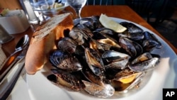 FILE - A plate of fire-roasted mussels.