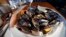 FILE - A plate of fire-roasted mussels.