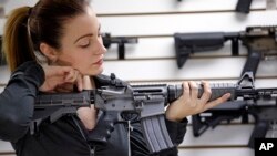 FILE - A gun shop owner demonstrates a Ruger AR-15 semi-automatic rifle, Nov. 7, 2017, in Lynnwood, Washington.