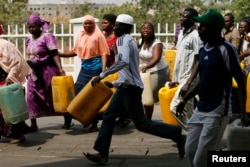 A man breaks out of the queue as he rushes to a kerosene cooking fuel pump during the launch of the "kero correct" scheme at a Nigerian National Petroleum Corporation (NNPC) mega petrol station in Abuja, Jan. 23, 2015.