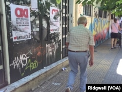 A man walks past a "No" campaign poster during a referendum in central Athens, Greece, July 5, 2015.