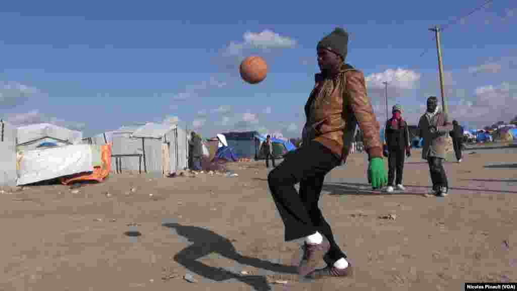 A migrant is playing soccer in the "Jungle" in Calais, France (Nicolas Pinault/VOA)