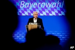 FILE - German Interior Minister and chairman of the German Christian Social Union party Horst Seehofer delivers a speech at a party convention of the CSU in Munich, Germany, Sept. 15, 2018.