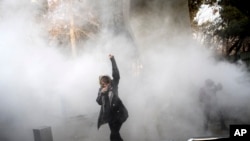 FILE - In this Dec. 30, 2017 file photo taken by an individual not employed by the Associated Press and obtained by the AP outside Iran, a university student attends a protest inside Tehran University.