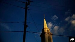 En imagen de archivo del martes 11 de abril de 2017, el sol pega en la torre de una iglesia bautista en Georgia. (AP Foto/David Goldman, archivo)