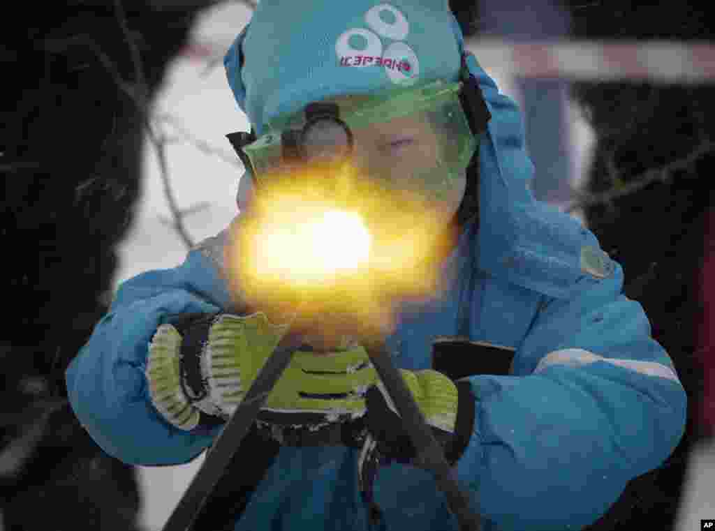 A boy to shoots a machine gun with blanks, at a weapon exhibition during a military show outside St.Petersburg, Russia.