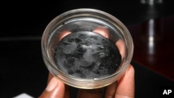 FILE: A sample of crude oil from Uganda's untapped source of petroleum is displayed in the capital city, Kampala, Jan. 27, 2010. 