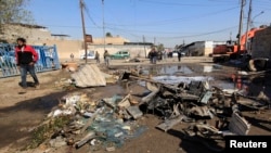 A man walks near the site of a car bomb attack in Baghdad, Feb. 6, 2014. 