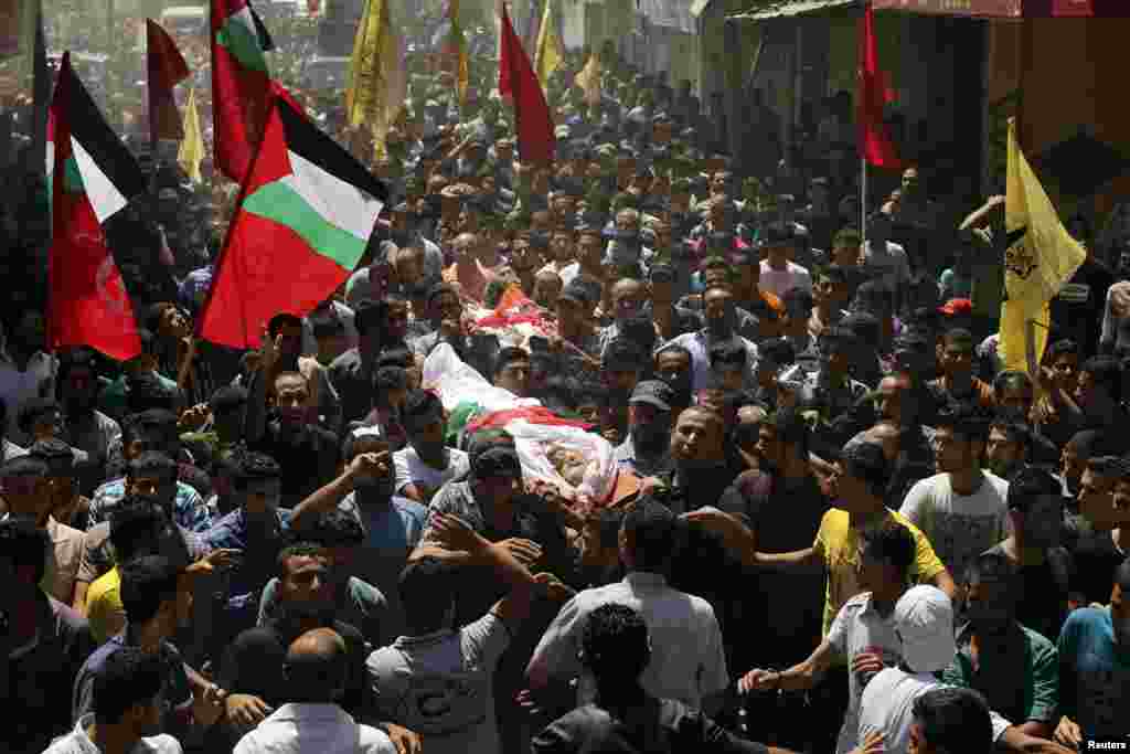 Mourners carry the bodies of Palestinians during their funeral in the town of Beit Hanoun in the northern Gaza Strip, July 9, 2014.