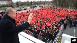 Turkey's President Recep Tayyip Erdogan waves to a group of workers at the airport in Ankara, Turkey, Dec. 7, 2017 prior to his departure on a two-day official visit to Greece. 