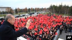 Recep Tayyip Erdogan acena para um grupo de operários antes de iniciar a visita a Grécia, 7 de Dezembro, 2017.