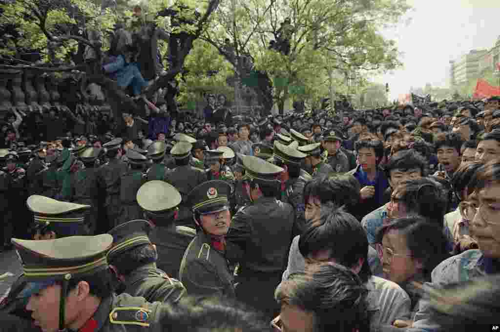 Para demonstran mencoba menerobos penjagaan polisi untuk berbaris ke Alun-alun Tiananmen di Beijing, 27 April 1989. (AP/Sadayuki Mikami)