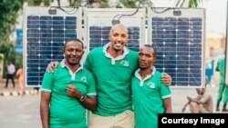 Le Rwandais Henri Nyakarundi (au centre), entouré de deux membres de son équipe, est l'inventeur du kiosque solaire, à Kigali, au Rwanda, le 25 janvier 2017. 