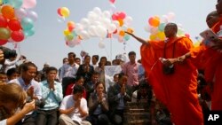 Buddhist monks, right, chant and pray during a rally in front of Royal Palace to call for the release of 23 detainees in Phnom Penh, file photo. 