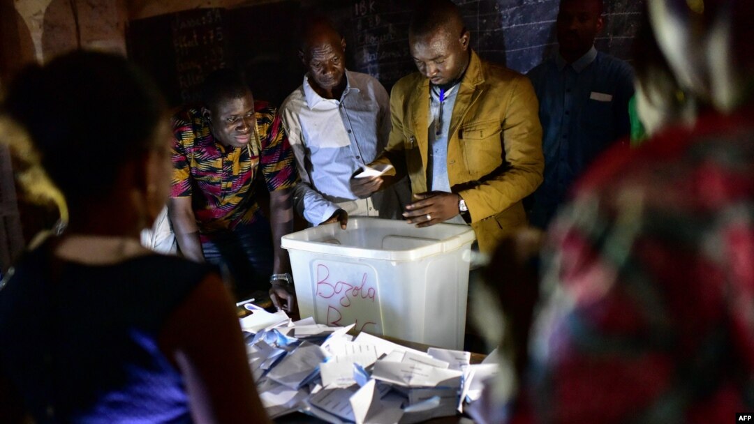 Electoral officials count ballot papers at the polling station on July 29, 2018 in Bamako, during Malian presidential elections.