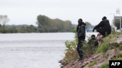 Les Soudanais attendent près de l'eau à Ouistreham, France, le 5 octobre 2017.