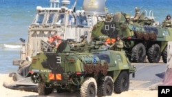 FILE - Soldiers sit atop amphibious vehicles as NATO troops participate in the NATO sea exercises BALTOPS 2015, meant to reassure the Baltic Sea region allies in the face of a resurgent Russia, in Ustka, Poland, June 17, 2015.