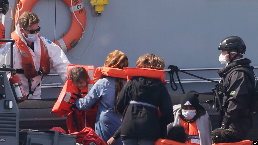 A Border Force vessel brings a group of people thought to be migrants into the port city of Dover, England, from small boats, Aug. 8, 2020.