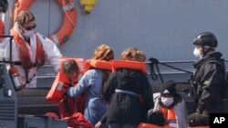 A Border Force vessel brings a group of people thought to be migrants into the port city of Dover, England, from small boats, Aug. 8, 2020.