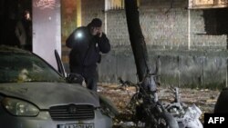 A policeman examines a crime scene after an explosion in which an Ukrainian lawmaker, Ihor Mosiychuk, was wounded and his bodyguard killed in Kyiv, Oct. 25, 2017.