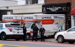 Polisi New York berjaga di Rumah Duka Andrew T. Cleckley di wilayah Brooklyn, New York, 29 April 2020. (Foto: dok). Meningkatnya kasus meninggal akibat COVID-19, membuat layanan rumah duka kewalahan dan harus menyediakan truk-truk berpendingin khusus untuk menyimpan jenazah di luar gedung.