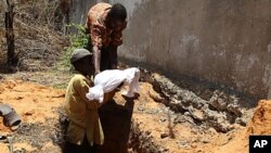 Internally displaced Somali men bury the body of a child who died of malnourishment in Hodan district, south of Mogadishu, Sept. 20, 2011.