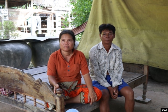 Keo Eat, 52, a deputy Prey Khla commune chief, decided to join the ruling Cambodian People’s Party after being served with a court summons shortly before the deadline to defect. He's shown with his wife, Keo Sarin.