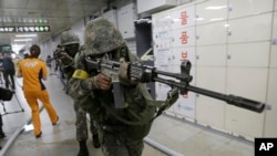South Korean army soldiers aim their weapons during an anti-terror drill as part of Ulchi Freedom Guardian exercise, at Sadang Subway Station in Seoul, South Korea, Wednesday, Aug. 19, 2015.